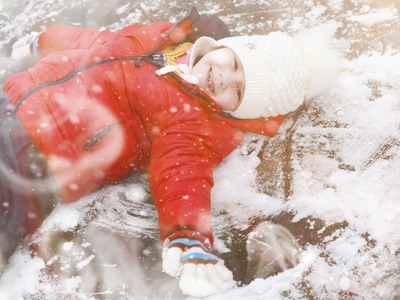 Ett barn leker i snön.