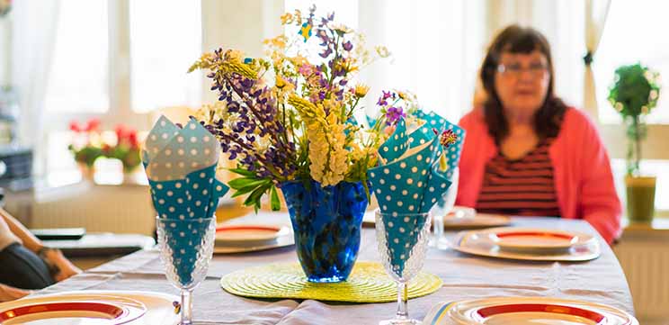 Dukat bord med blommor och servetter i glasen. 